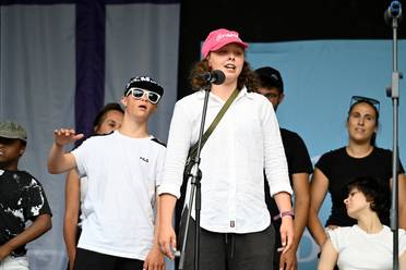 Jahresfest 2025 – Festfeier – Schülerinnen und Schüler führen bei der Festfeier auf der Bühne ihr Musikstück „Gemeinsam – Zusammen“ auf. Zwei Personen stehen nahe an einem Mikrofon.