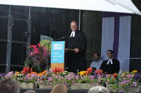 Jahresfest 2026 – Festgottesdienst – Der stellvertretende Vorstandsvorsitzende steht am Pult auf der Bühne, hinter ihm sitzen v.l. ein Diakon und ein weiterer Pfarrer Jahresfest 2026 – Festgottesdienst – Der stellvertretende Vorstandsvorsitzende steht am Pult auf der Bühne, hinter ihm sitzen v.l. ein Diakon und ein weiterer Pfarrer