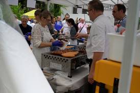 Jahresfest 2025 – Blick in ein Zelt mit kulinarischem Angebot. Einige Personen kümmern sich um das Grillgut und die Vorbereitung von Speisen zur Ausgabe. Jahresfest 2025 – Blick in ein Zelt mit kulinarischem Angebot. Einige Personen kümmern sich um das Grillgut und die Vorbereitung von Speisen zur Ausgabe.