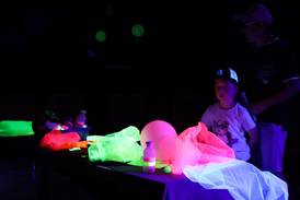 Jahresfest 2025 – Eine junge Person steht im dunklen Raum vor bunt leuchtenden Gegenständen – Schwarzlicht-Zirkus in der Bergschule. Jahresfest 2025 – Eine junge Person steht im dunklen Raum vor bunt leuchtenden Gegenständen – Schwarzlicht-Zirkus in der Bergschule.