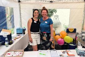 Jahresfest 2026 - Zwei Personen stehen im zentralen Info-Stand im Schlosshof und lachen Richtung Kamera Jahresfest 2026 - Zwei Personen stehen im zentralen Info-Stand im Schlosshof und lachen Richtung Kamera