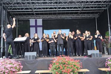 Jahresfest 2025 – Festfeier – Ein Chor singt während der Festfeier auf der Bühne im Park.