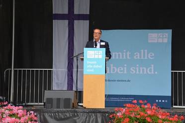 Jahresfest 2025 – Festfeier – Der Vorstandsvorsitzende der Diakonie Stetten steht auf der Bühne und spricht zu Beginn der Festfeier.